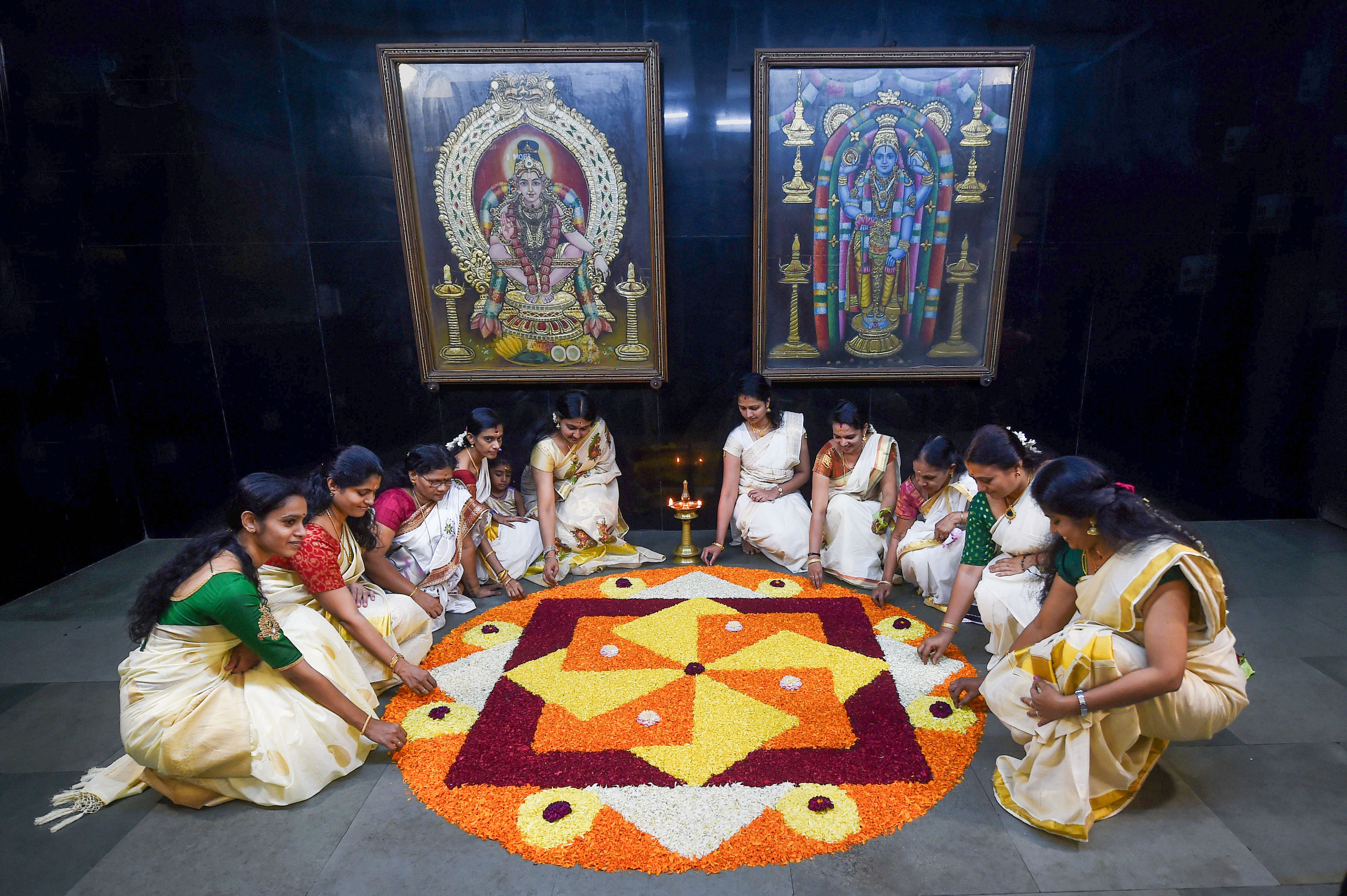 Women make a floral rangoli at a temple during Onam celebrations in Chennai - PTI