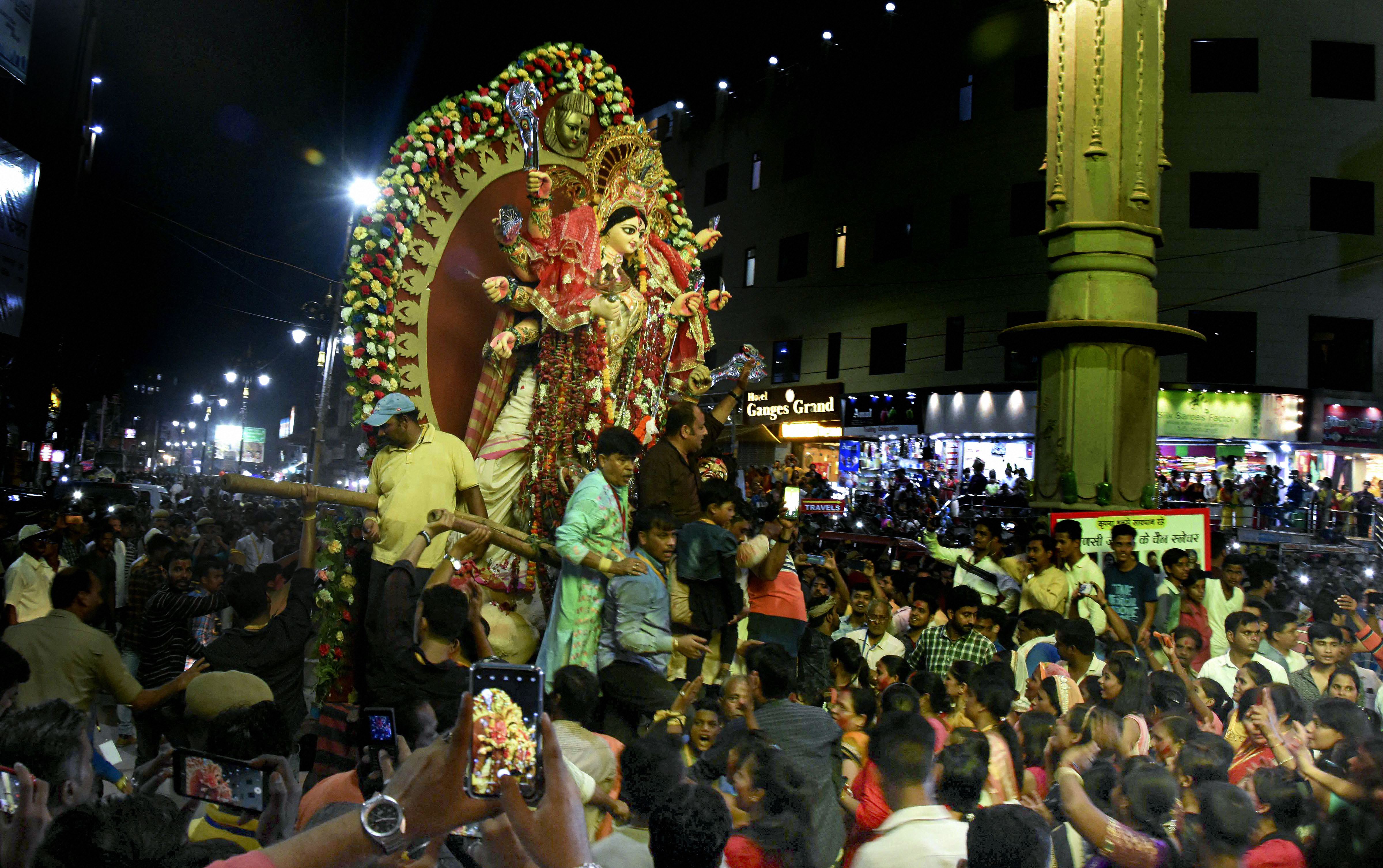Devotees gather for a procession to immerse an idol of godess Durga, in Varanasi - PTI