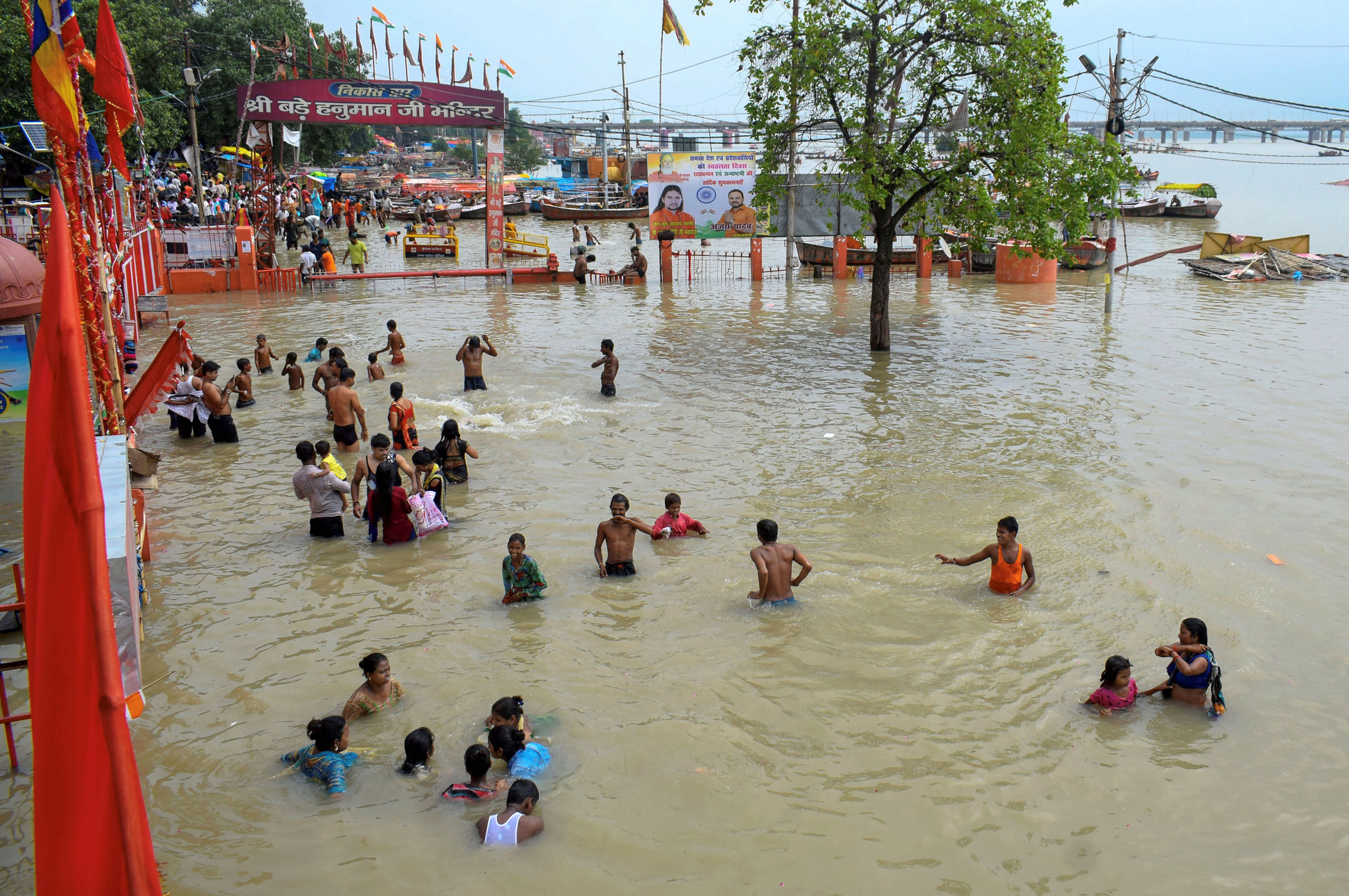Devotees walk through the flood water in front of Bade Haumanji Temple near Sangam, confluence of the Ganges, the Yamuna and mythical Saraswati rivers, in Prayagraj - PTI