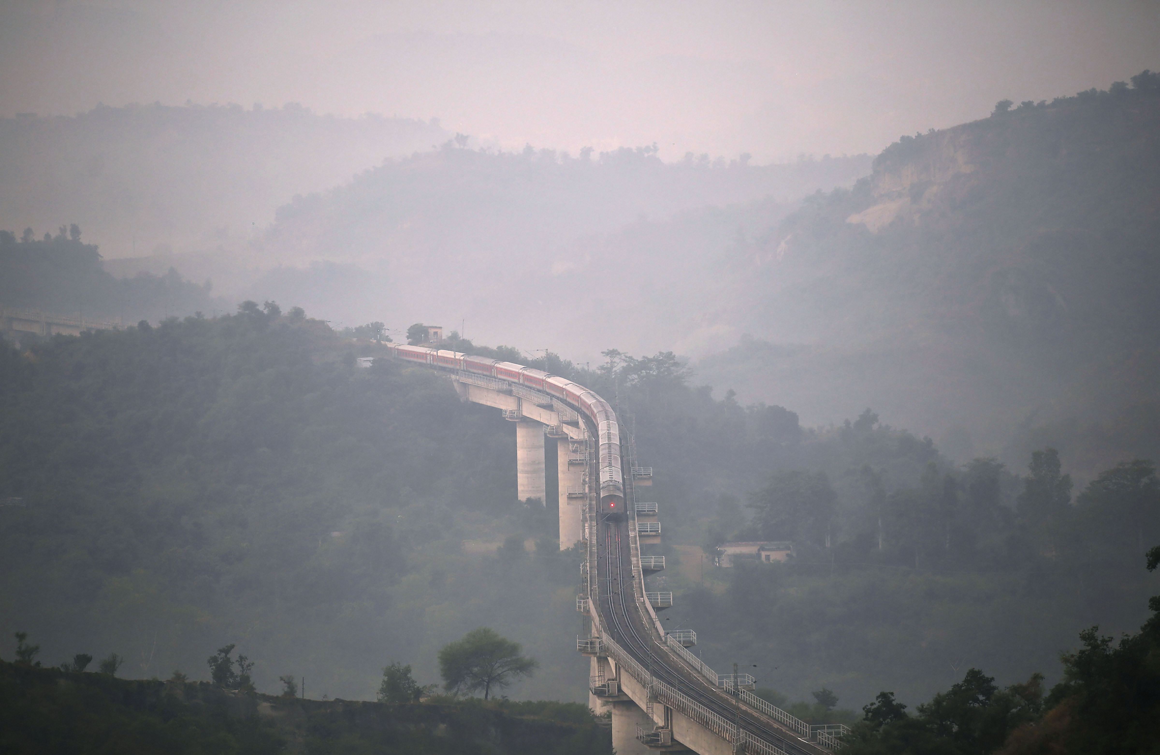A train runs on a rail bridge towards Katra amind heavy fog, in Jammu - PTI