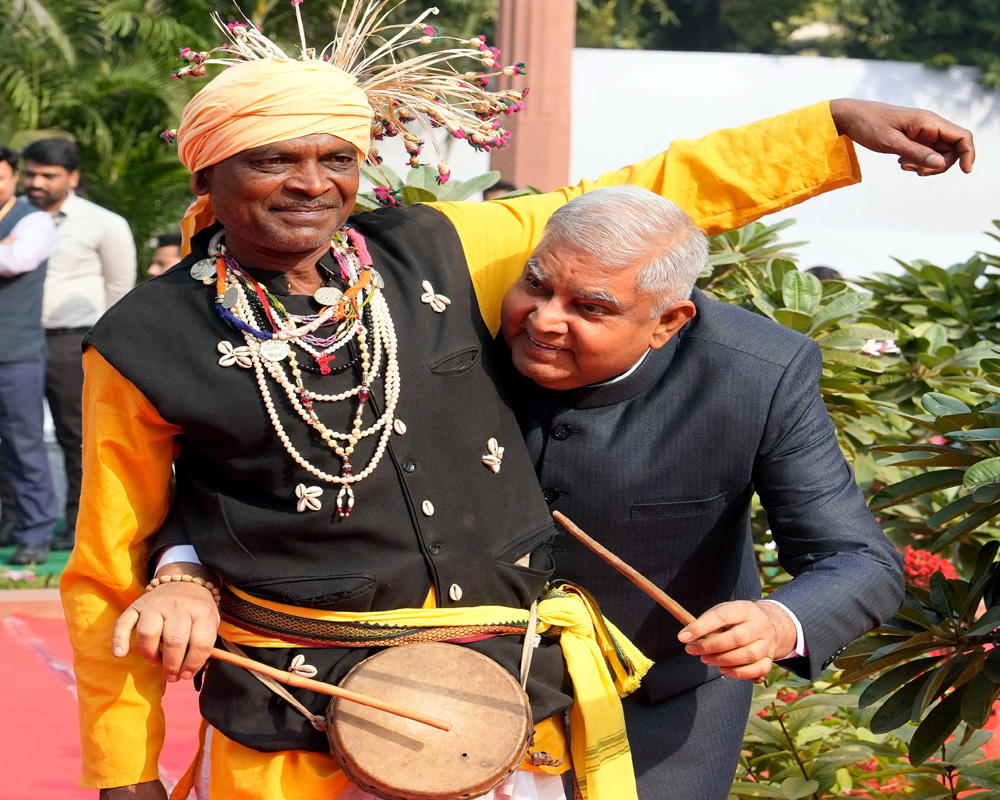 Vice President Jagdeep Dhankhar plays a drum after paying tribute to freedom fighter Birsa Munda on his birth anniversary, at Parliament House complex in New Delhi, Tuesday. (PTI Photo)