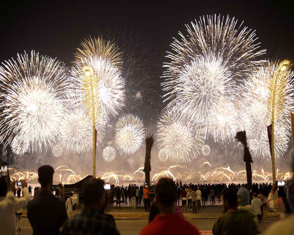Fans watch fireworks after the World Cup inauguration match between Qatar and Ecuador at the Corniche sea promenade in Doha, Qatar, Nov. 20, 2022.